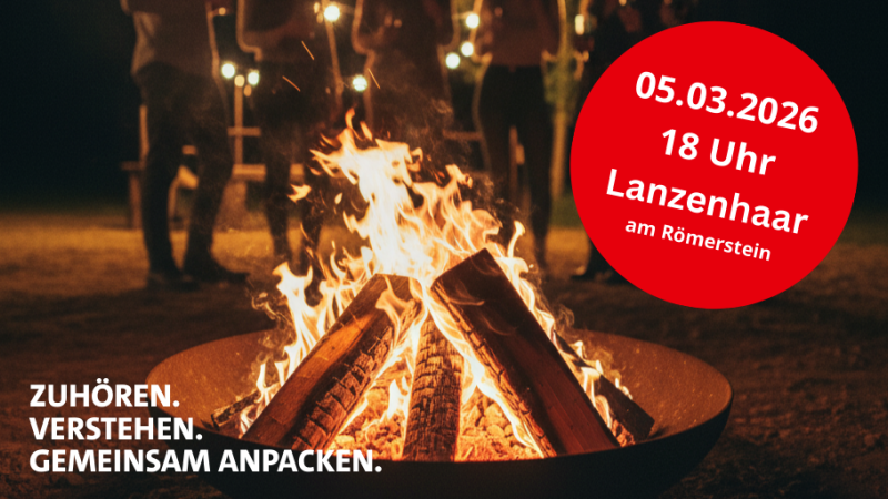 Feuerschale im Vordergrund mit Flammen und Menschen stehen im Hintergrund.